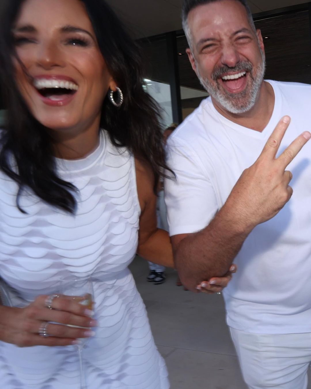 Marc and Heidi laughing at a white party